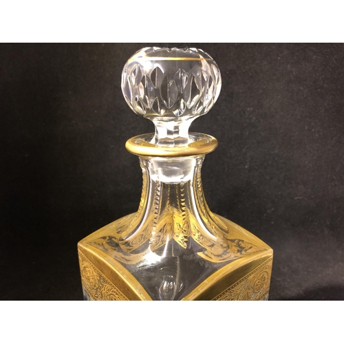 60 - Saint Louis - a Thistle Pattern decanter and stopper; and two tumblers, banded in gold with scrollin... 