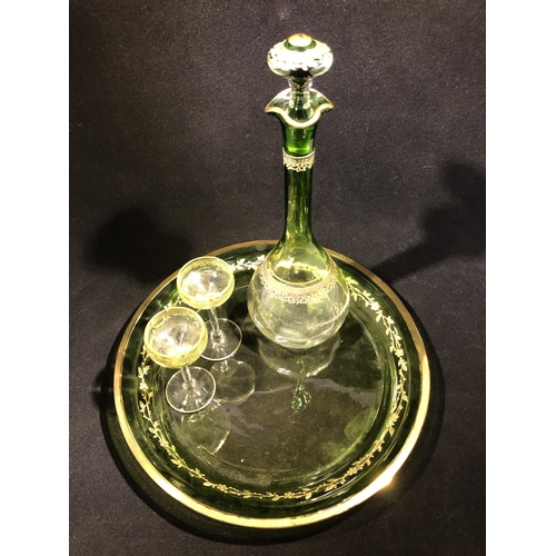 114 - Moser - a graduated green glass liquor set, comprising decanter and stopper and two glasses gilded w... 