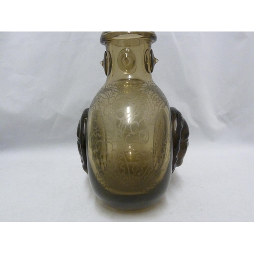 56 - Seguso - a  dark amber glass flask, the flattened globular body applied with a female head to each s... 