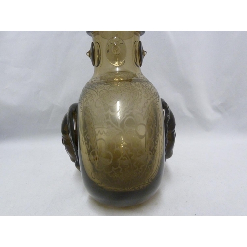 56 - Seguso - a  dark amber glass flask, the flattened globular body applied with a female head to each s... 