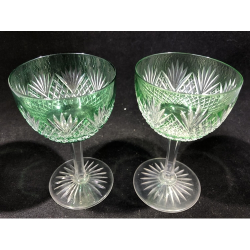 246 - Stevens and Williams - a pair of green overlay wine glasses, the bowls cut through to colourless gla... 