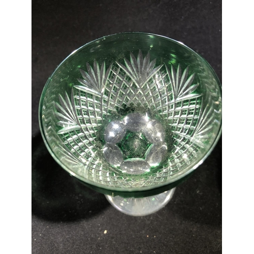 246 - Stevens and Williams - a pair of green overlay wine glasses, the bowls cut through to colourless gla... 