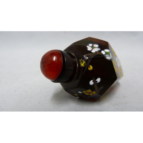 95 - Chinese Glass - a deep amber glass faceted snuff bottle enamelled in polychrome colours with prunus ... 