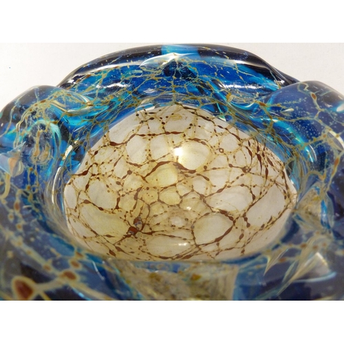 26 - Mdina glass - a bowl with everted rim, the textured blue glass rim folded over a sand and rust strea... 