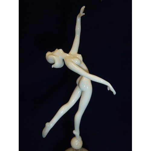 90 - Istvan Komaromy - a dancer figure, in white glass and balletic pose atop a white striated ball and c... 