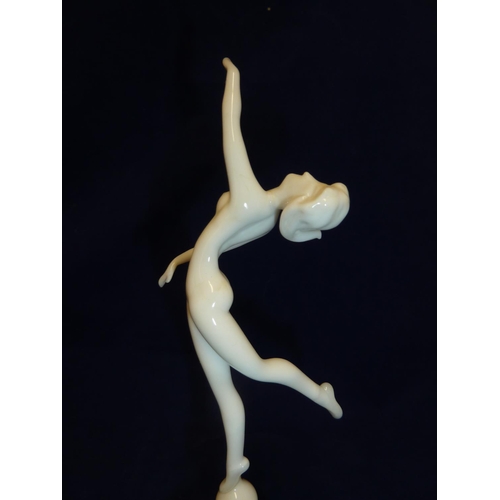 90 - Istvan Komaromy - a dancer figure, in white glass and balletic pose atop a white striated ball and c... 