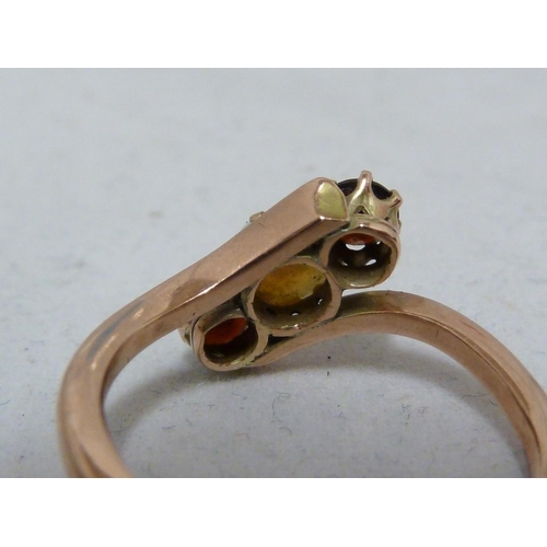 65 - A opal and garnet ring, set in rose coloured metal, unmarked, ring size K; and two opal set earrings... 