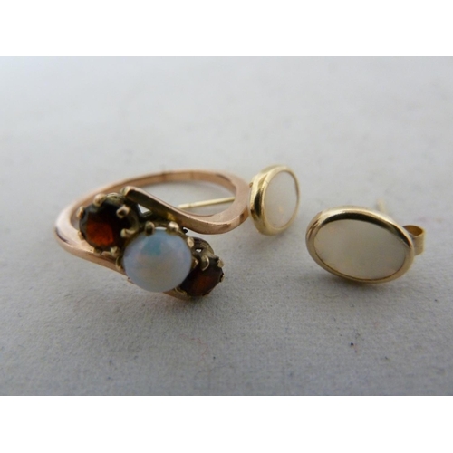 65 - A opal and garnet ring, set in rose coloured metal, unmarked, ring size K; and two opal set earrings... 