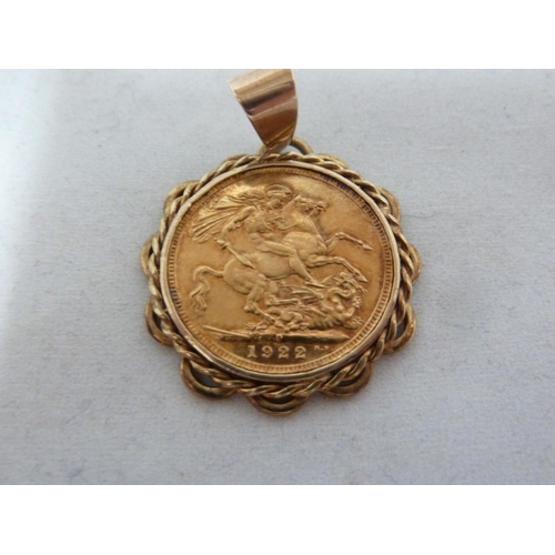 10 - A gold Sovereign coin, dated 1922, mounted as a pendant and with a yellow gold fancy link chain mark... 