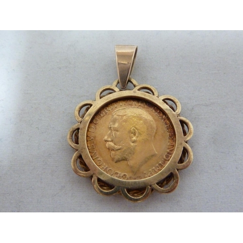 10 - A gold Sovereign coin, dated 1922, mounted as a pendant and with a yellow gold fancy link chain mark... 