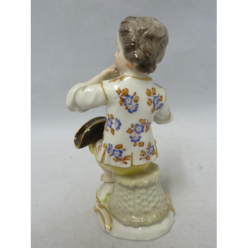 111 - A Meissen porcelain figure, of a seated boy eating grapes, on foliate scroll base, blue crossed swor... 