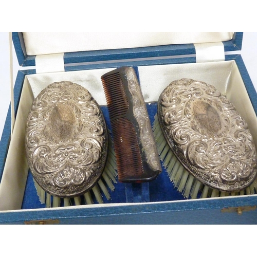 18 - A Victorian style silver mounted dressing table set in fitted cases, the backs repousse decorated wi... 