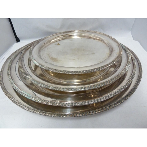 21 - A graduated set of four silver plated salvers, circular with gadrooned edge, the centre engraved wit... 