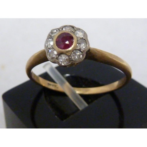 38 - A ruby and diamond ring, the central ruby encircled by eight round brilliant cut stones set in an 18... 