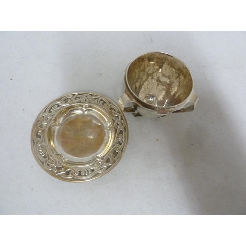 7 - An Arts and Crafts silver egg cup, the plannished body applied with three barbed handles forming a t... 