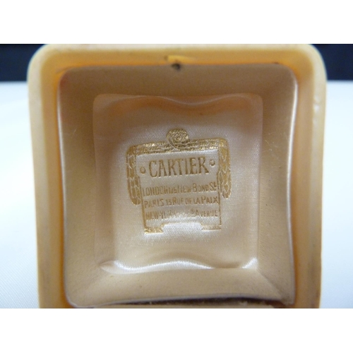 34 - Cartier - a bakelite ivorine ring box, push button fastening, cream silk and velvet lined and stampe... 