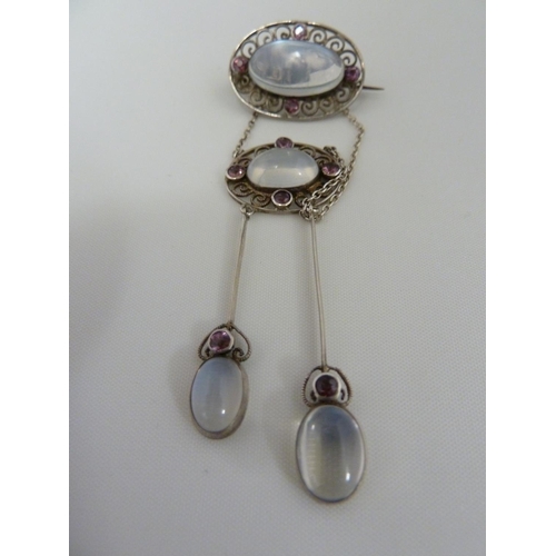 36 - A Belle Epoque pendant and brooch set, the white metal filigree work supporting oval moonstones and ... 