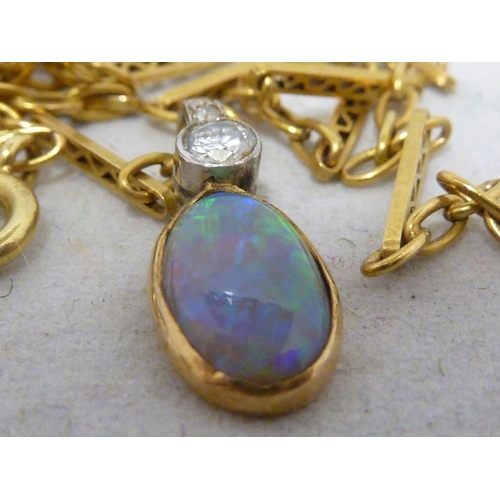 44 - An opal and diamond pendant, the oval opal set in yellow metal, surmounted by a single round brillia... 