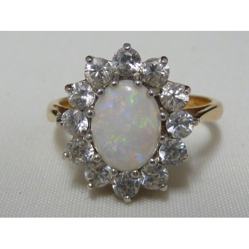 40 - A light opal ring and earring set, the opals encircled by CZ stones, the ring of 9ct yellow gold, ri... 