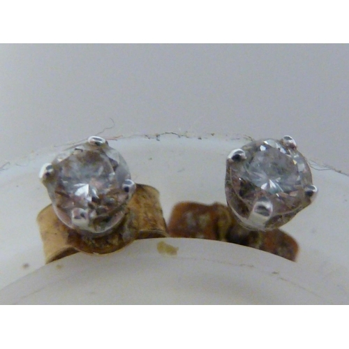 57 - A pair of 0.1 carat diamond studs, set in white metal, 0.9grms (2)