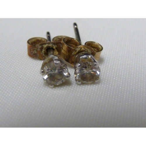 57 - A pair of 0.1 carat diamond studs, set in white metal, 0.9grms (2)