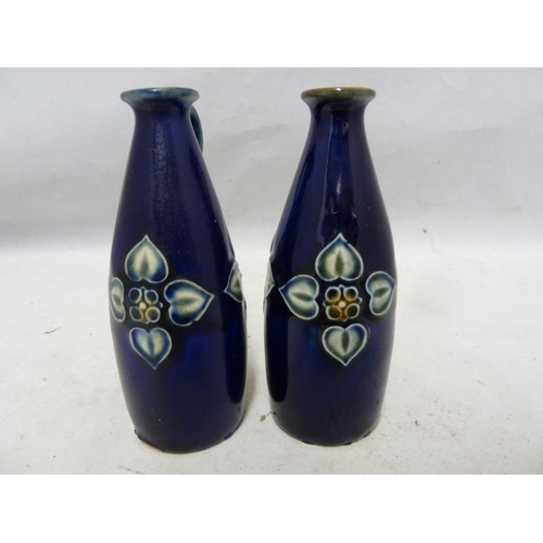 103 - A pair of Royal Doulton stoneware miniature jugs, each with high placed strap handle and decorated w... 