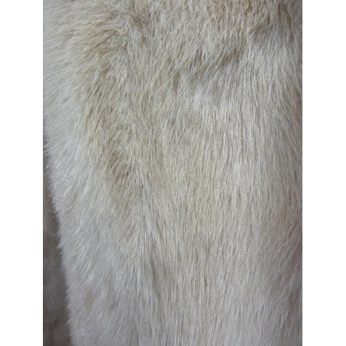 114 - A cream 3/4 length mink coat, with leather bow details to cuffs, size 10 approx