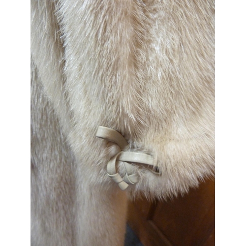 114 - A cream 3/4 length mink coat, with leather bow details to cuffs, size 10 approx