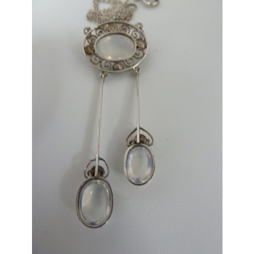 36 - A Belle Epoque pendant and brooch set, the white metal filigree work supporting oval moonstones and ... 