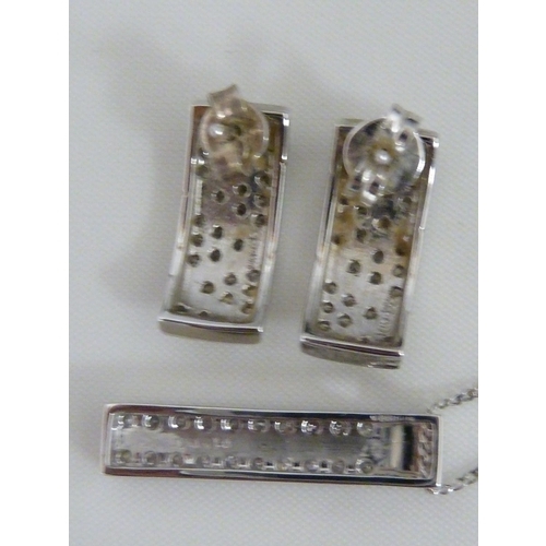 43 - A pair of white gold and diamond earrings, of curved bar form decorated with set with round diamonds... 