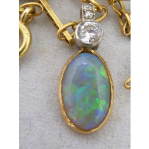 44 - An opal and diamond pendant, the oval opal set in yellow metal, surmounted by a single round brillia... 