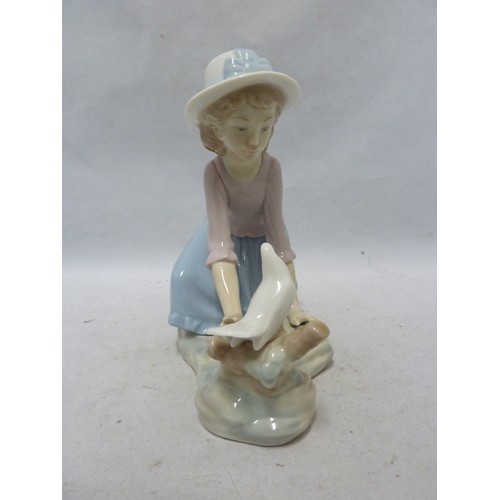 243 - Nao - a porcelain figure of a girl kneeling with a dove on a tree stump, 16.5cm high approx