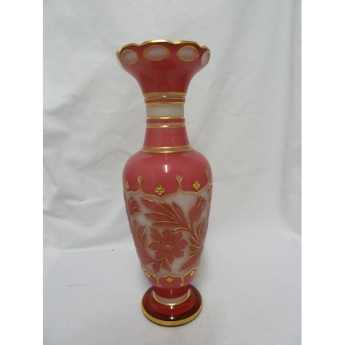 64 - Bohemian Glass - a pink over white cameo glass vase, cut through with flowers and with gilded highli... 