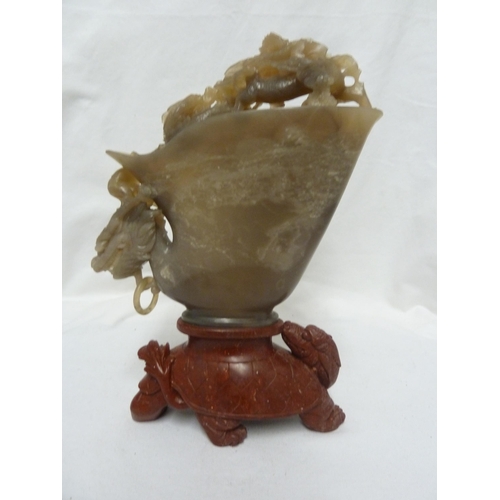 248 - A Chinese hardstone libation cup form sculpture, decorated with dragons fighting for a flaming pearl... 