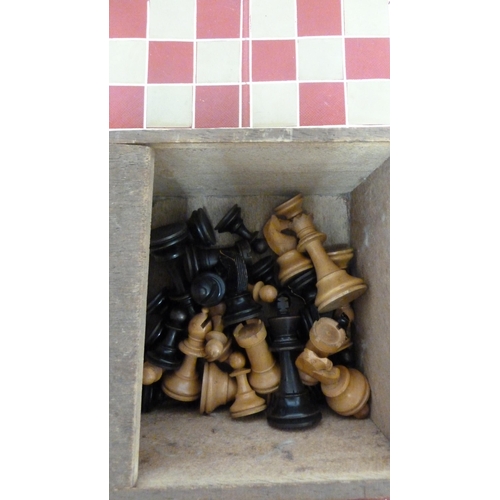 126 - A carved wood chess set, in a box; and a tooled leather chess board of Red and white tolled in gilt ... 