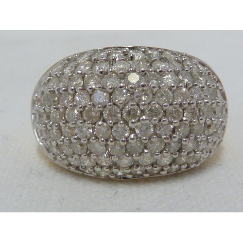 29 - A bombe shaped diamond cluster ring, the circular stones set in rows in white metal on a yellow meta... 