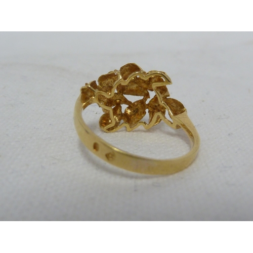 38 - A yellow metal ring, tooled with leaf motifs in high relief, ring size N 1/2, 2.8grms