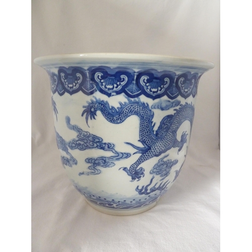 177 - A Chinese fish bowl jardiniere, decorated in blue with a coiled five claw dragon chasing a flaming p... 