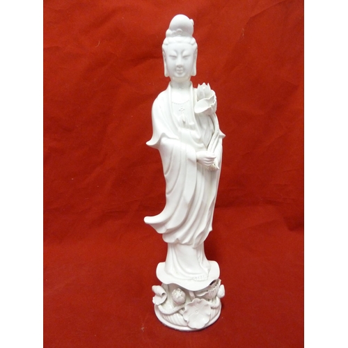 179 - A Dehua Chinese porcelain figure of Guan Yin, standing holding a large lotus flower the base similar... 