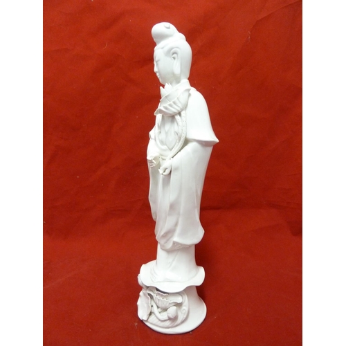 179 - A Dehua Chinese porcelain figure of Guan Yin, standing holding a large lotus flower the base similar... 