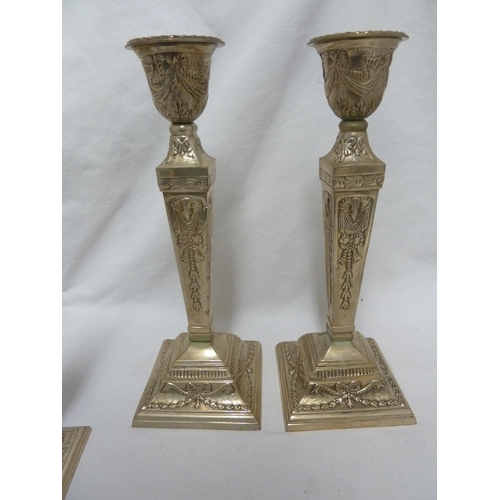 183 - Two pairs of white metal candlesticks, chased with ribbon bows and laurel wreathes, 30cm and 20cm hi... 