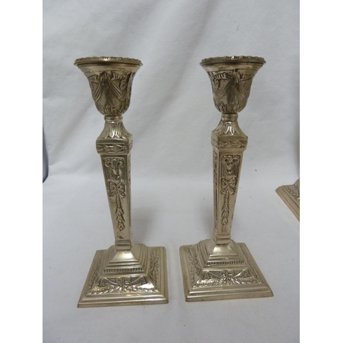 183 - Two pairs of white metal candlesticks, chased with ribbon bows and laurel wreathes, 30cm and 20cm hi... 