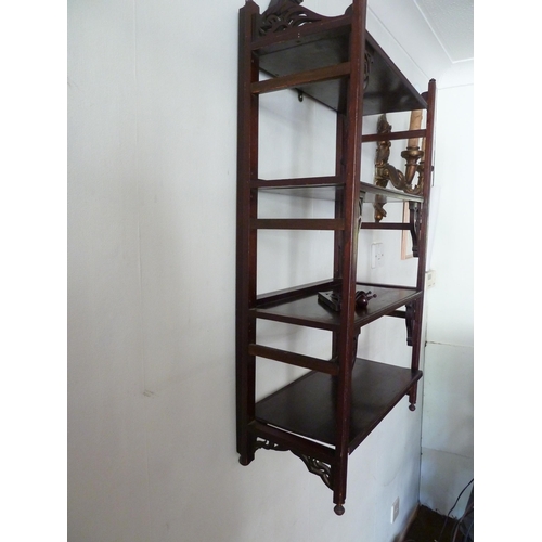 200 - A set of folding hanging shelves, with pierced brackets and beneath a broken pediment with vase fini... 