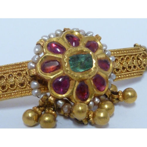 40 - A Kashmiri gem set bar brooch, the central emerald encircled by eight rubies within strung seed pear... 