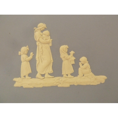 54 - A Wedgwood pale blue jasper oval plaque, sprigged with a mother and children carrying flowers, withi... 