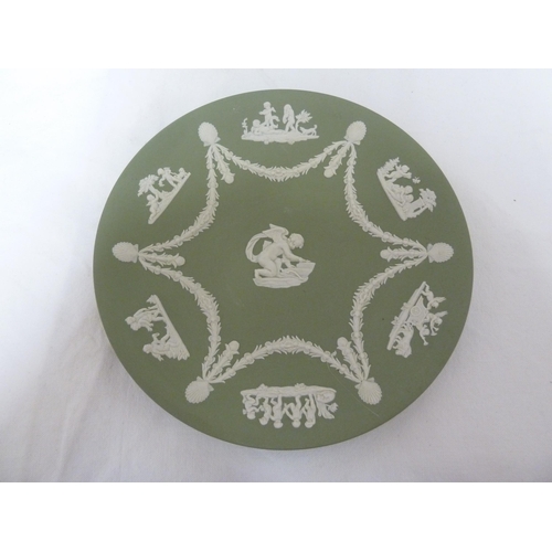 55 - Two Wedgwood Green Jasper plates, sprigged with Cupid sharpening his arrow to the center, within six... 