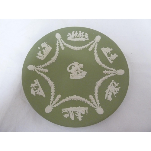 55 - Two Wedgwood Green Jasper plates, sprigged with Cupid sharpening his arrow to the center, within six... 