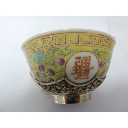 149 - A Chinese porcelain white metal mounted cup and saucer, the porcelain teabowl decorated with good fo... 