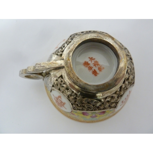 149 - A Chinese porcelain white metal mounted cup and saucer, the porcelain teabowl decorated with good fo... 