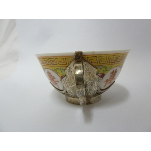 149 - A Chinese porcelain white metal mounted cup and saucer, the porcelain teabowl decorated with good fo... 